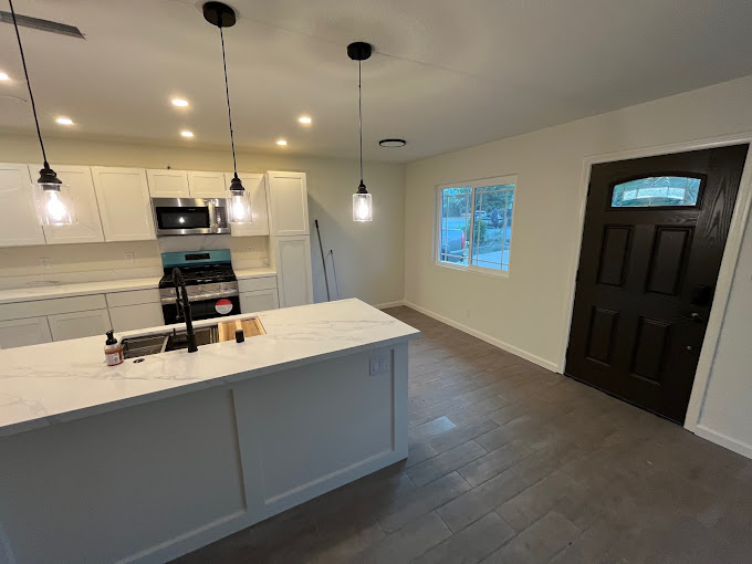 A kitchen with an island and a stove top oven